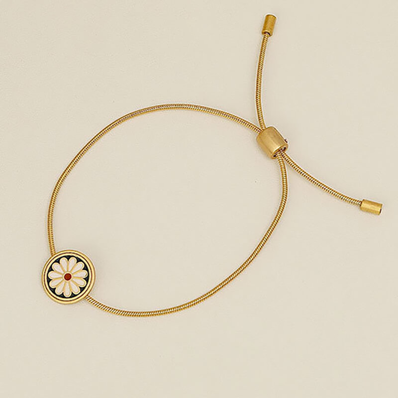 Pulsera con flor de margarita y cordón de acero dorado